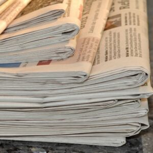A Stack of Folded Newspapers on a Surface