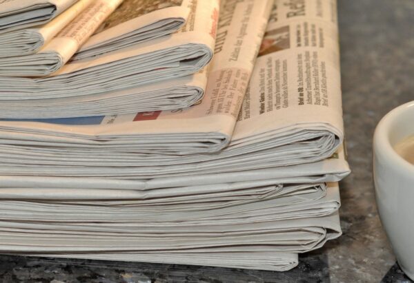 A Stack of Folded Newspapers on a Surface
